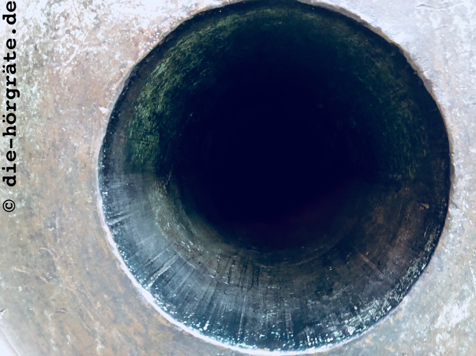 Blick in das Rohr einer Kartaune, altes Metall und ein schwarzes Loch