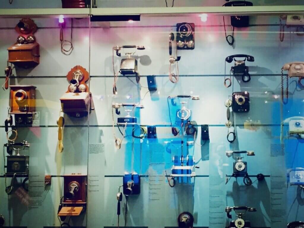 Sammlung alter Telefone in einer großen Vitrine